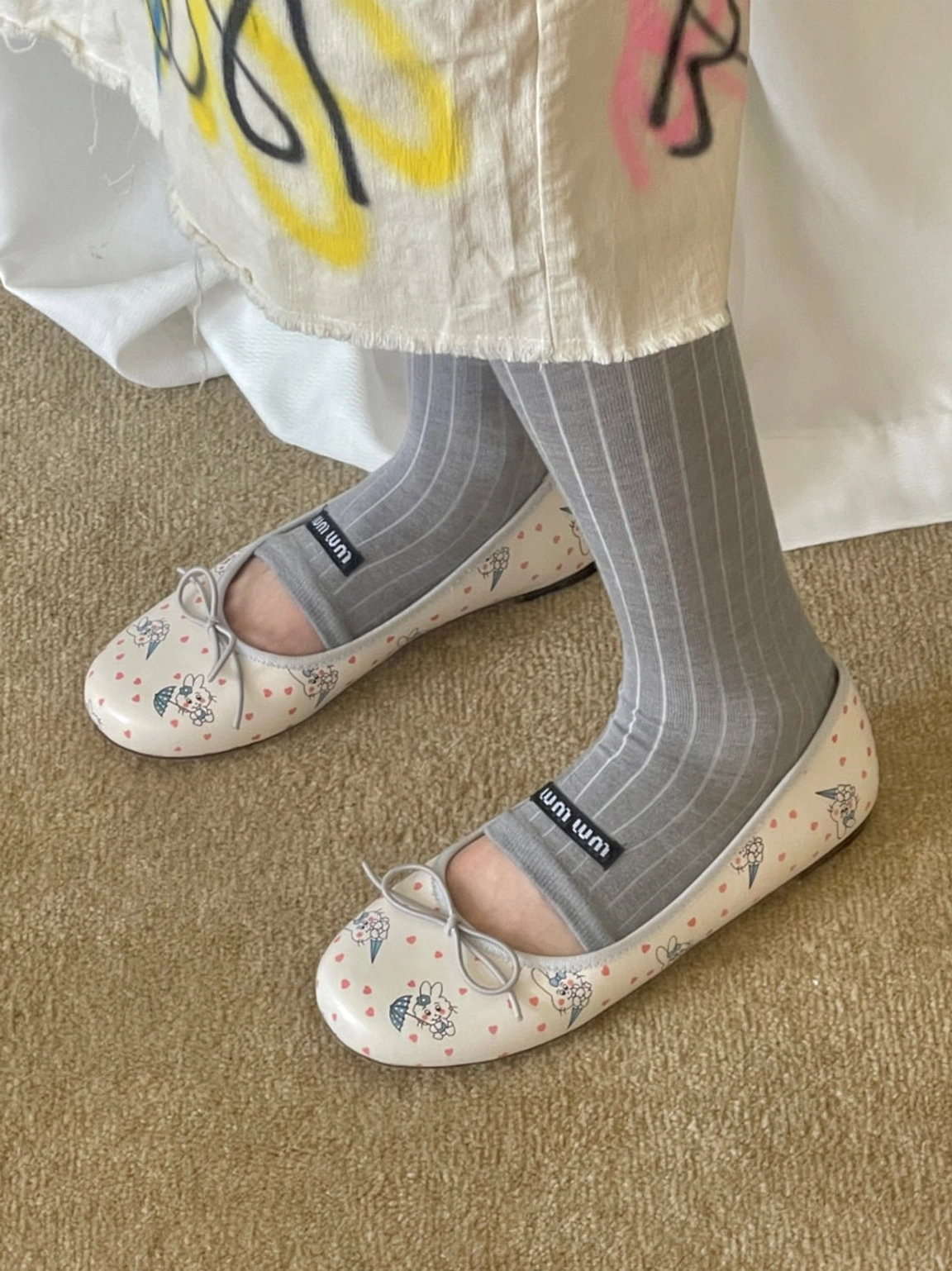 Low side view of whimsical printed square-toe ballet flats with front ribbon bow in Korean streetwear styling