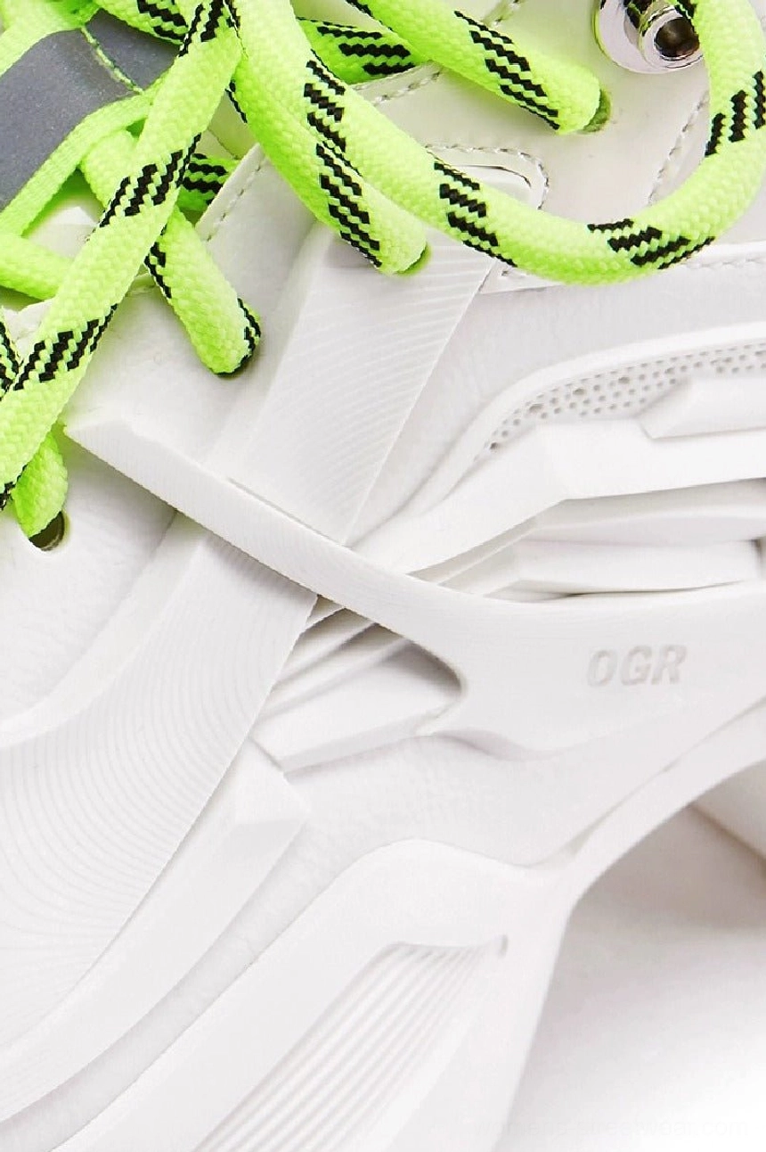 Close-up of a white 3D-printed-style platform sneaker upper showing geometric overlays, contrast striped laces, structured lace zone, and technical streetwear detailing