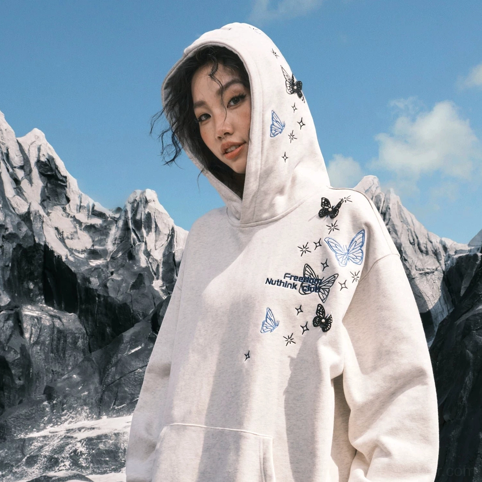 Close-up front view of a White Ash oversized pullover hoodie with butterfly and star embroidery and kangaroo pocket