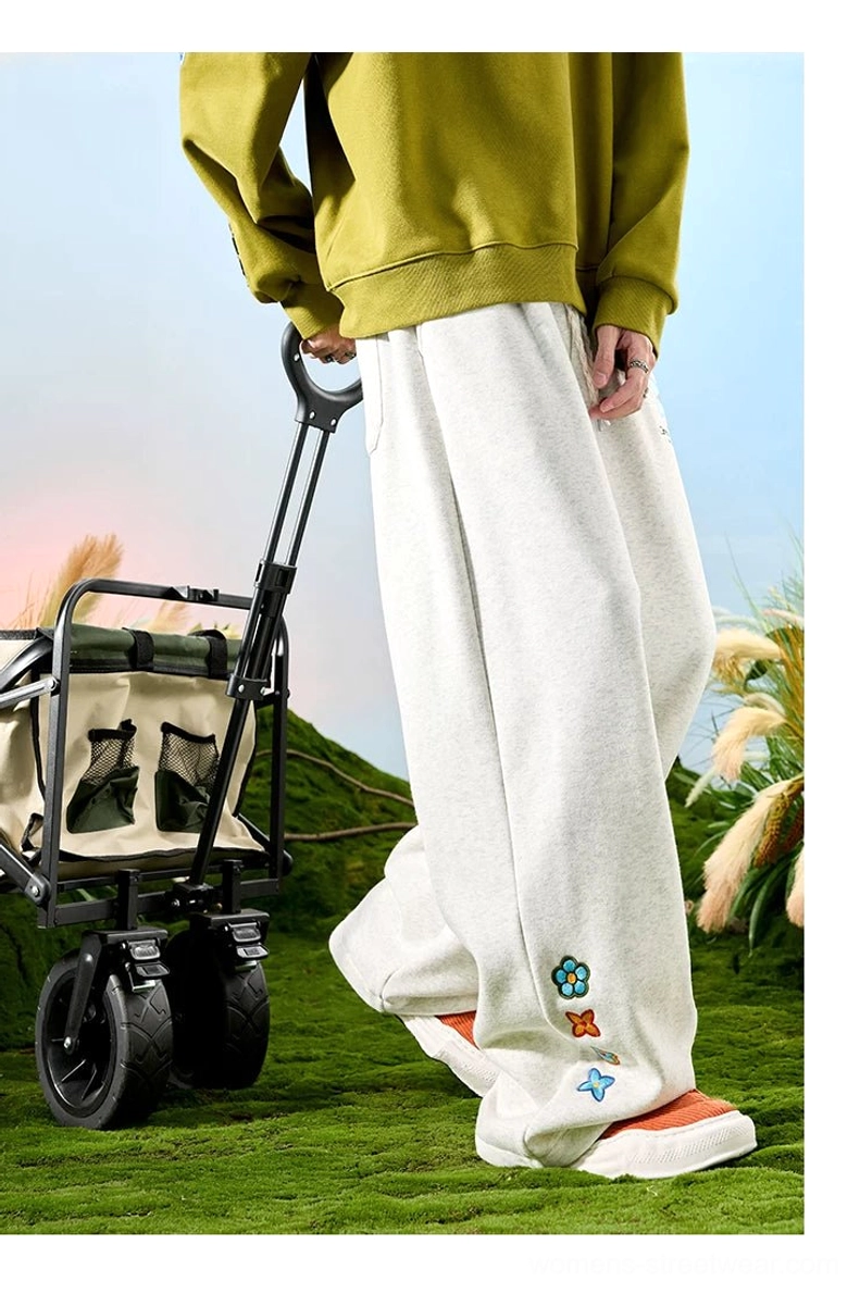White ash embroidered floral wide-leg sweatpants in a back view showing the relaxed draped streetwear silhouette