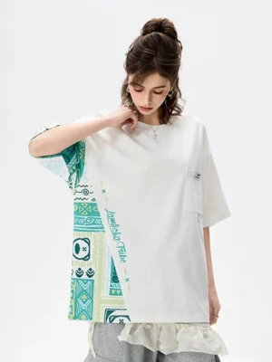 White asymmetric tribal panel oversized heavyweight cotton T-shirt front view on female model with green patterned sleeve and side insert