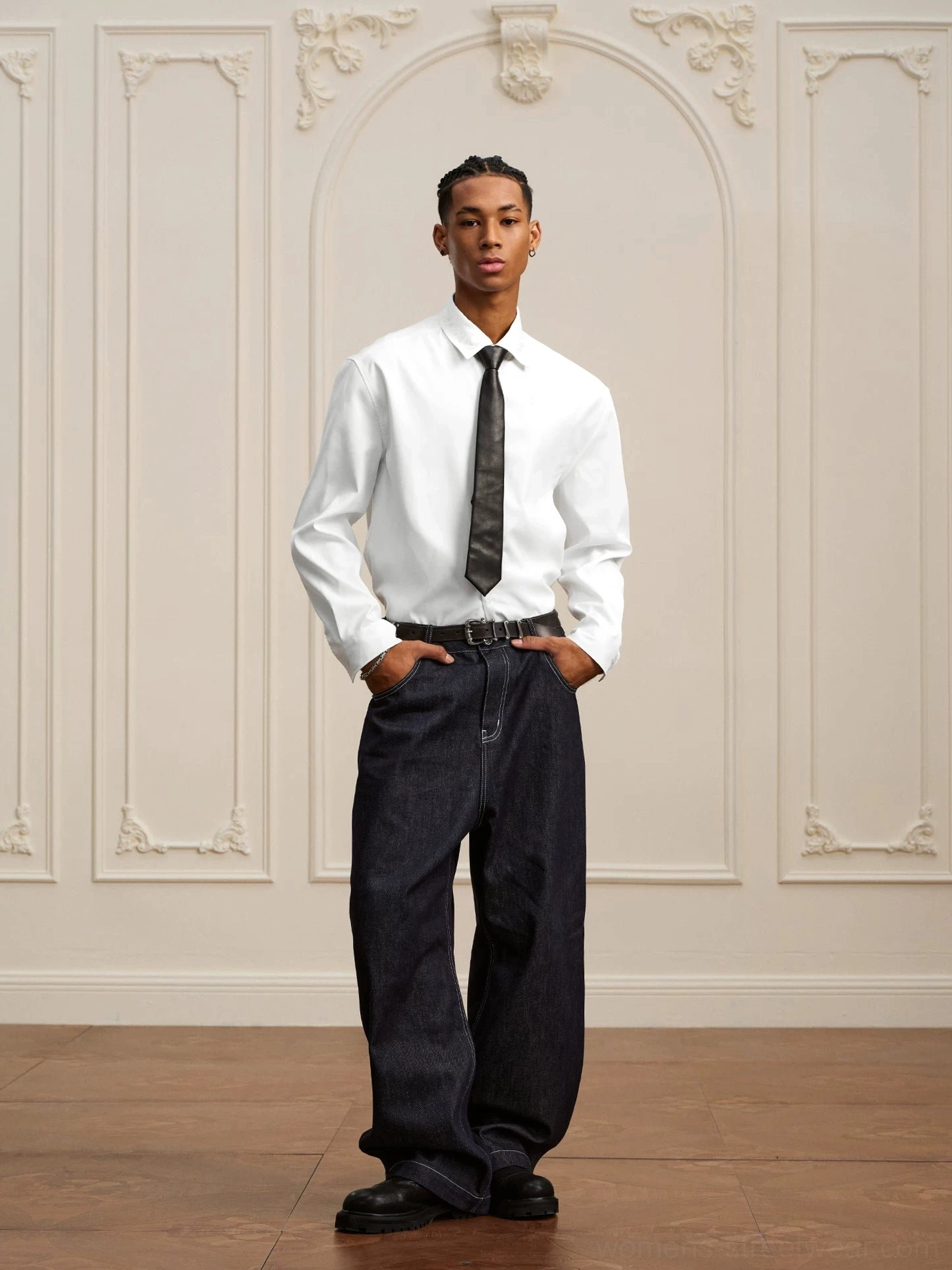 White baroque embroidered high-low dress shirt styled with a black necktie and dark wide-leg jeans