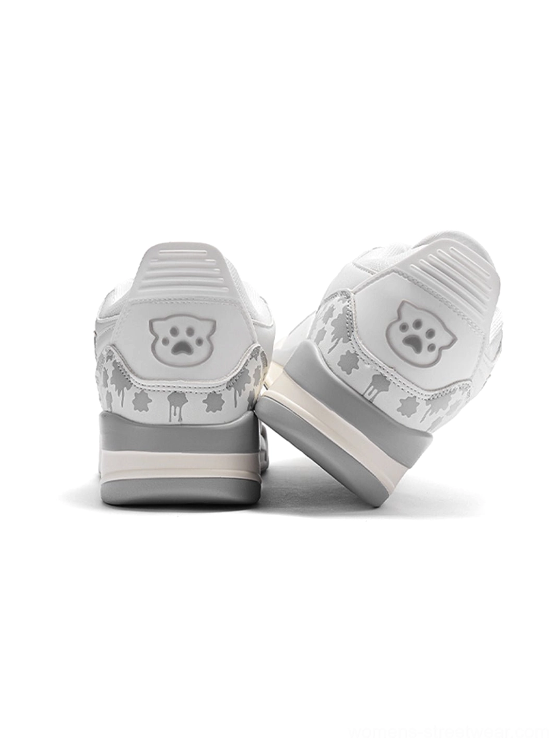 Rear view of white low-top basketball-inspired sneakers with playful heel artwork, layered gray and off-white midsole, and streetwear styling
