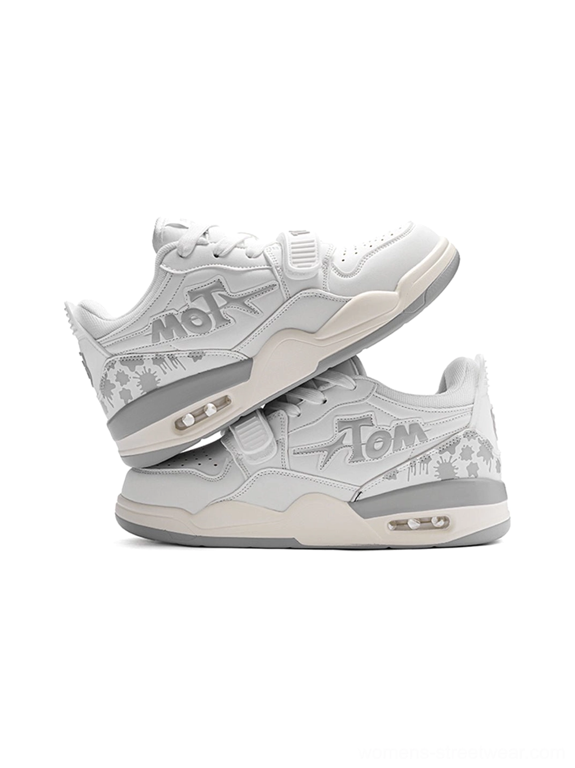 Top-down view of stacked white basketball-inspired streetwear court sneakers showing layered panels, graphic side details, and cushioned heel sole