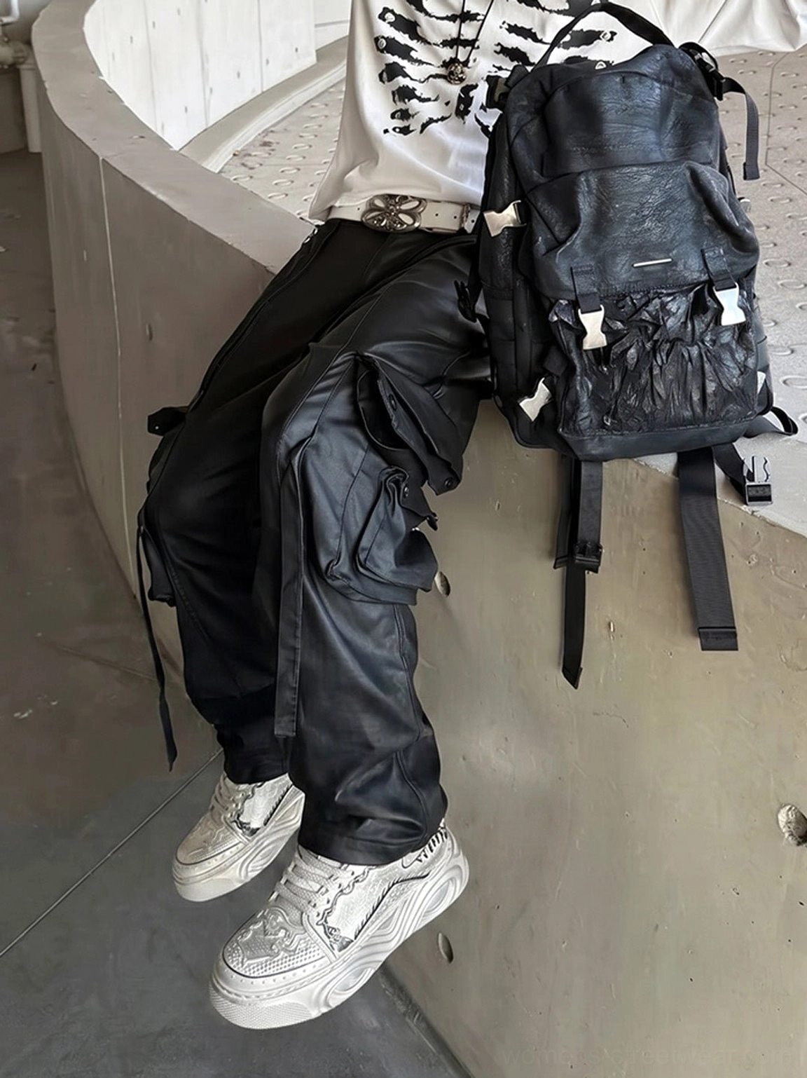 White bone-detail platform sneakers worn with black streetwear clothing in a casual urban concrete setting
