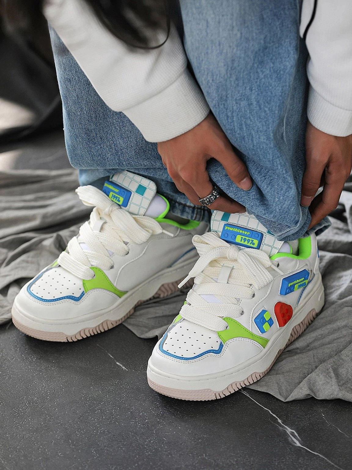 Overhead close-up of white building block skate sneakers showing the heart patch colorful block details and bright coordinated streetwear accents