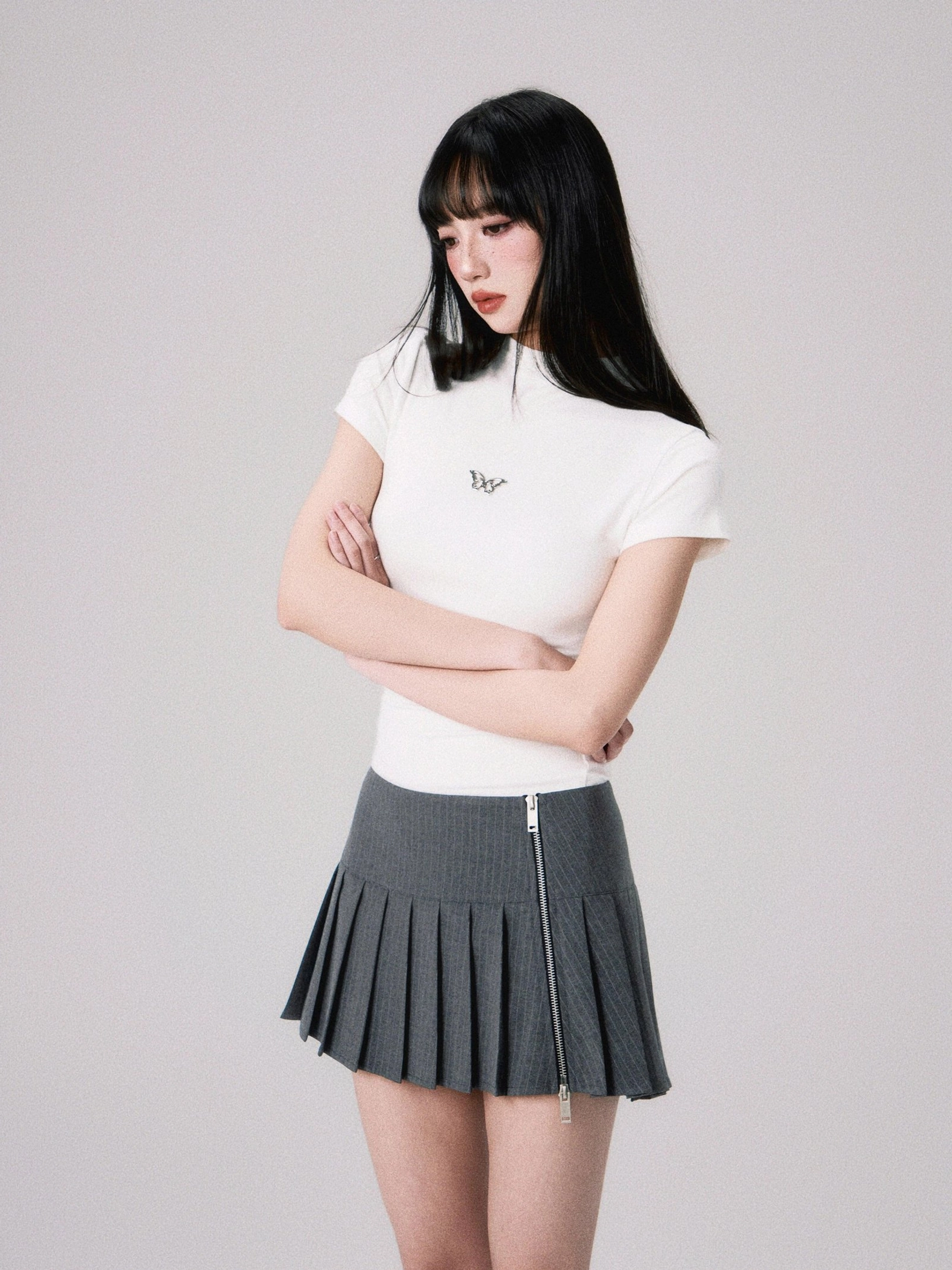 White butterfly embroidered fitted crop top paired with a side zipper pleated mini skirt