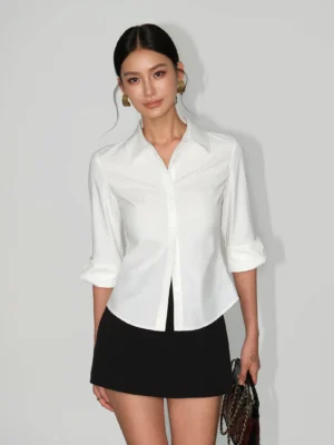 White contour curve tailored button-up shirt with pointed collar and rolled cuffs styled with a black mini skirt