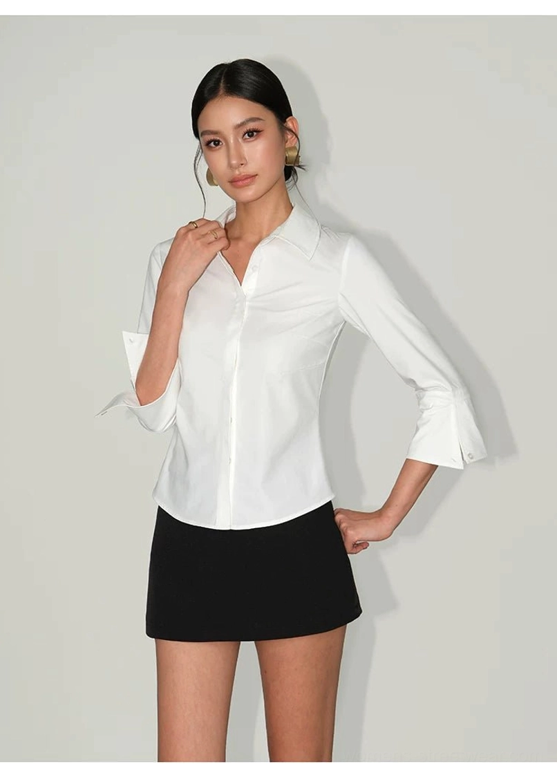 Side view of white contour curve tailored button-up shirt showing pointed collar curved hem and turn-up cuffs