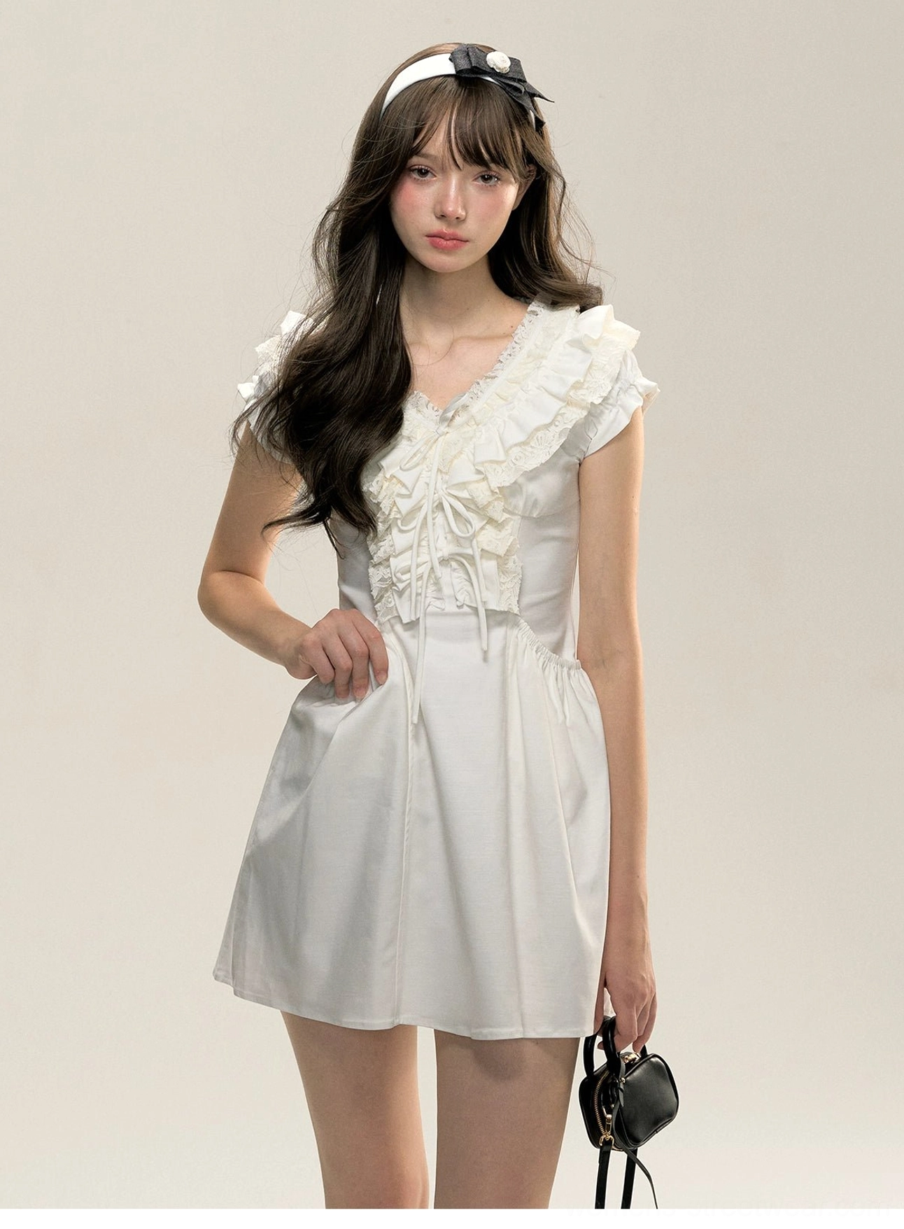 White cotton Victorian ruffle mini dress side-front view showing fitted waist and flutter cap sleeves