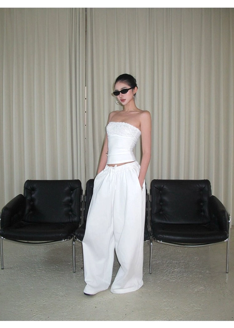 White cotton wide-leg streetwear pants styled with a strapless cropped top in a clean solid white outfit