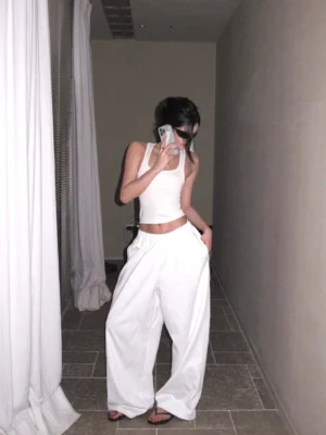 White cotton wide-leg streetwear pants styled with a slim cropped tank top, relaxed high-waisted silhouette in a mirror outfit view
