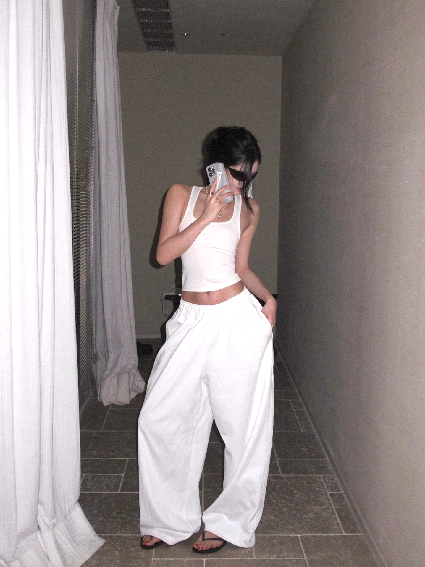 White cotton wide-leg streetwear pants styled with a slim cropped tank top, relaxed high-waisted silhouette in a mirror outfit view
