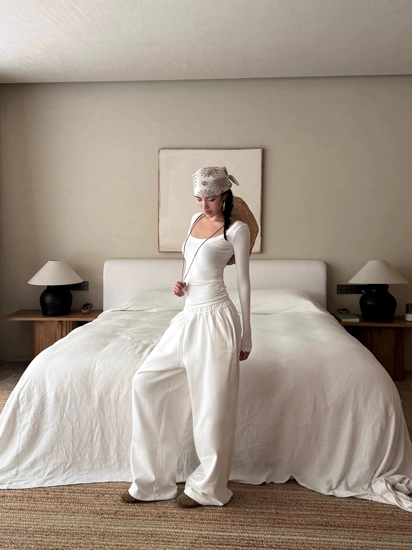 White cotton wide-leg streetwear pants styled with a fitted long-sleeve white top in a relaxed low-waist outfit