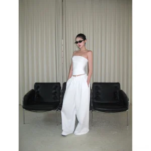 White cotton wide-leg streetwear pants styled with a strapless cropped top in a minimalist lounge, full-body front view