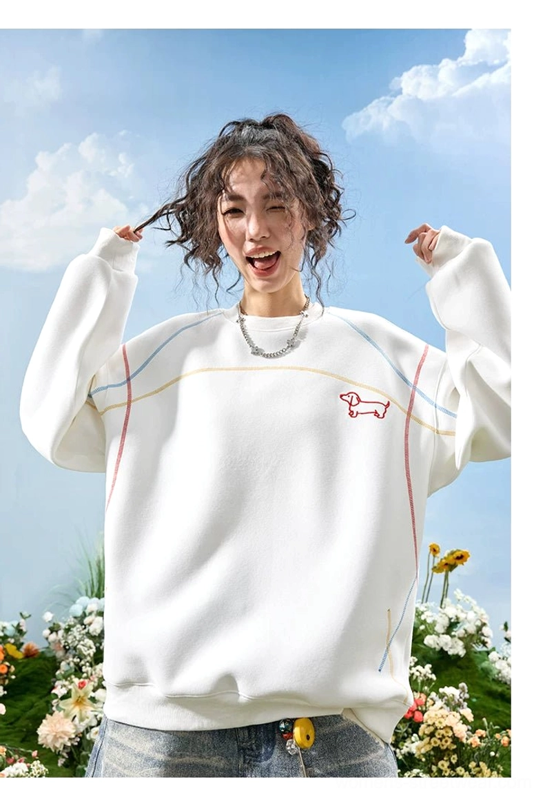 White oversized dachshund crewneck sweatshirt close-up with red embroidered dog motif and contrast shoulder stitching