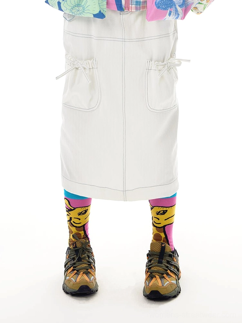 White denim utility pocket midi skirt front worn view with drawstring side pockets graphic socks and hiking shoes