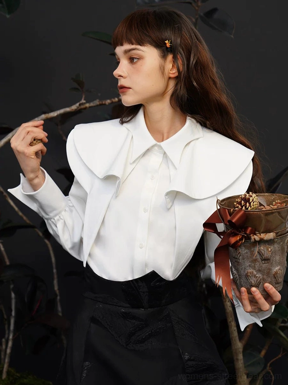 White detachable cape collar blouse shown in side profile with oversized layered collar, button front, long sleeves, and black skirt