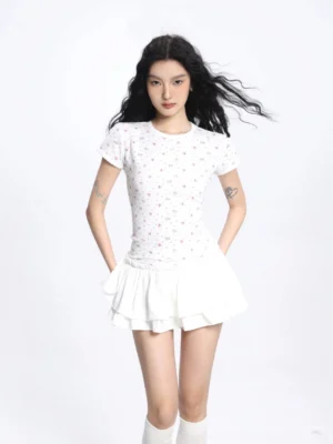 Front view of a white double layer ruffled mini skirt with a tailored high waist, styled with a cropped floral top and over the knee socks