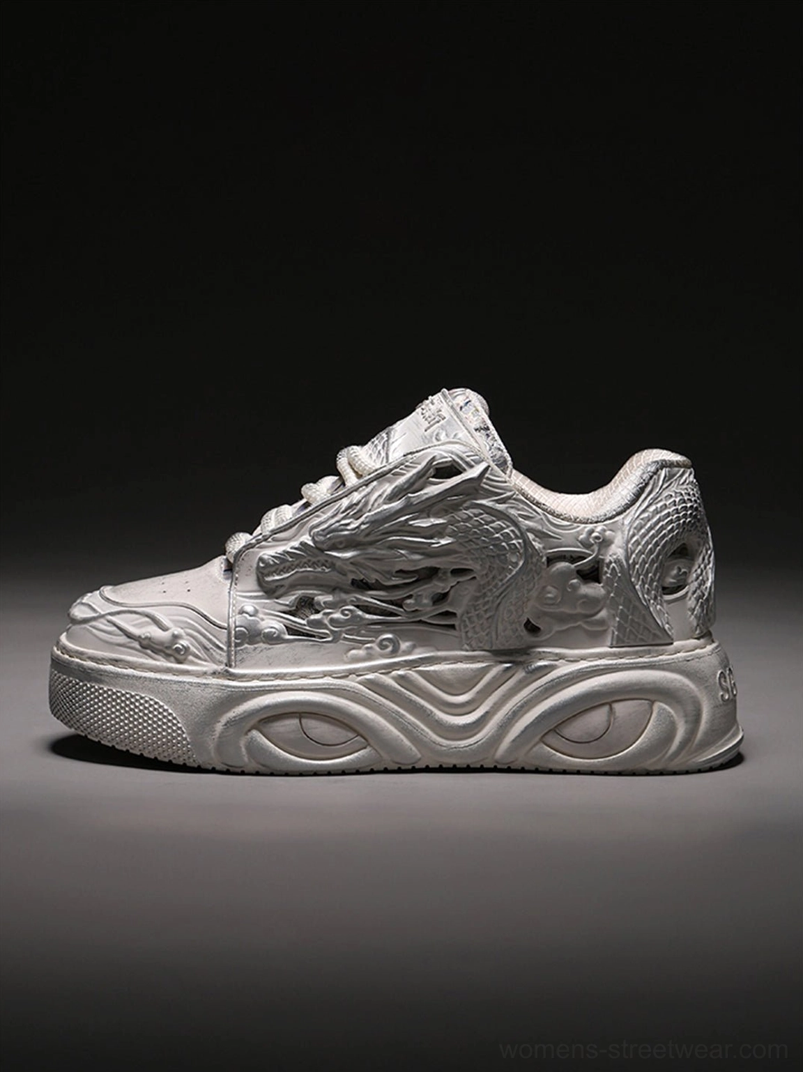 Right side profile of white dragon embossed platform sneakers showing the silver-white relief upper and wave-pattern sole