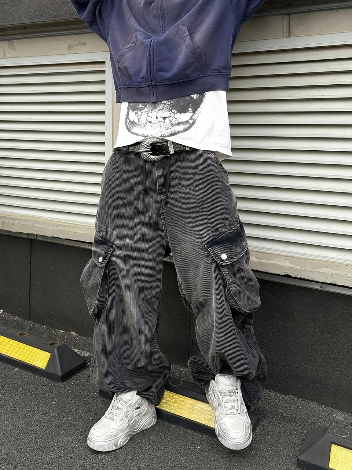 White dragon relief chunky sneakers styled with a cropped hoodie and washed cargo jeans on an urban street
