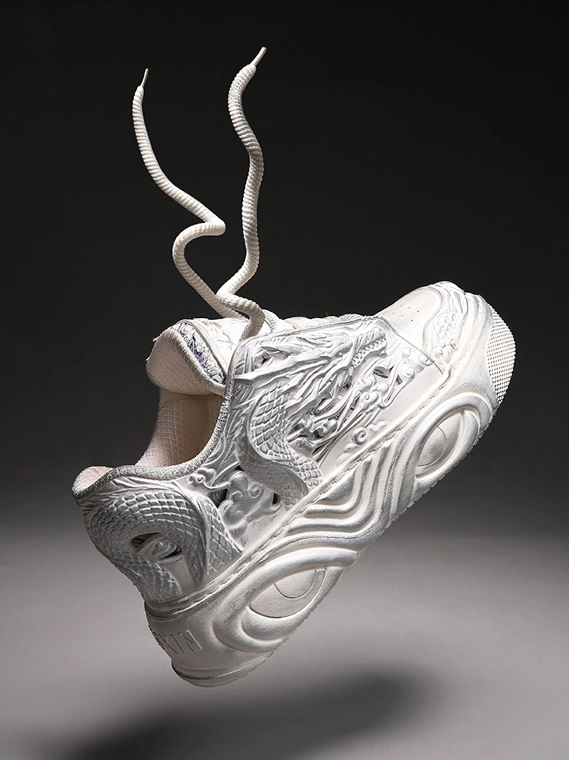 White dragon relief platform sneaker floating in a studio view with detailed 3D carving and a thick wavy sole
