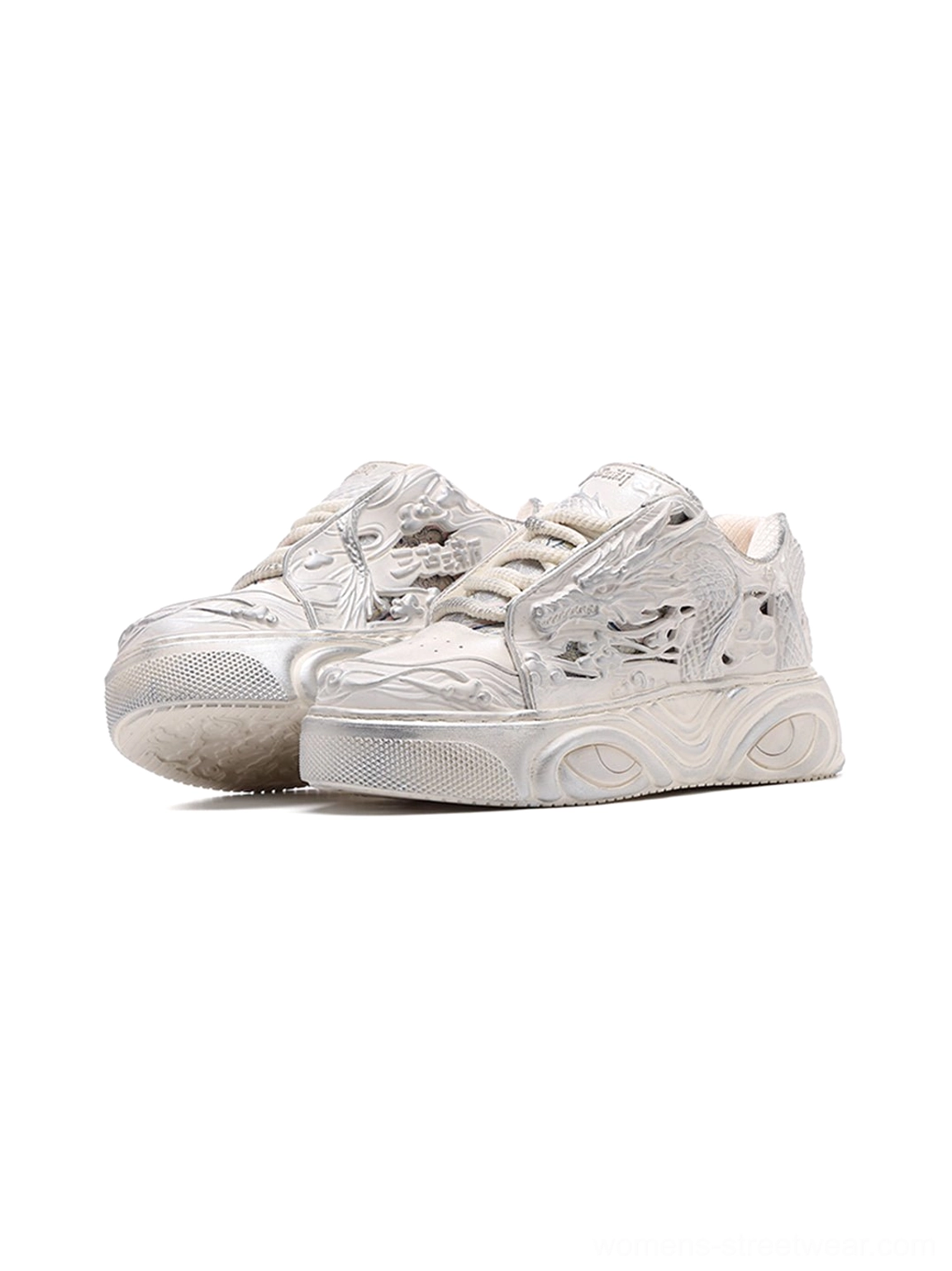 White dragon relief platform sneakers shown from a low front angle with an off-white distressed monochrome finish