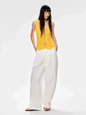 White adjustable drawstring wide-leg streetwear pants styled with a yellow tank top in a clean minimalist outfit