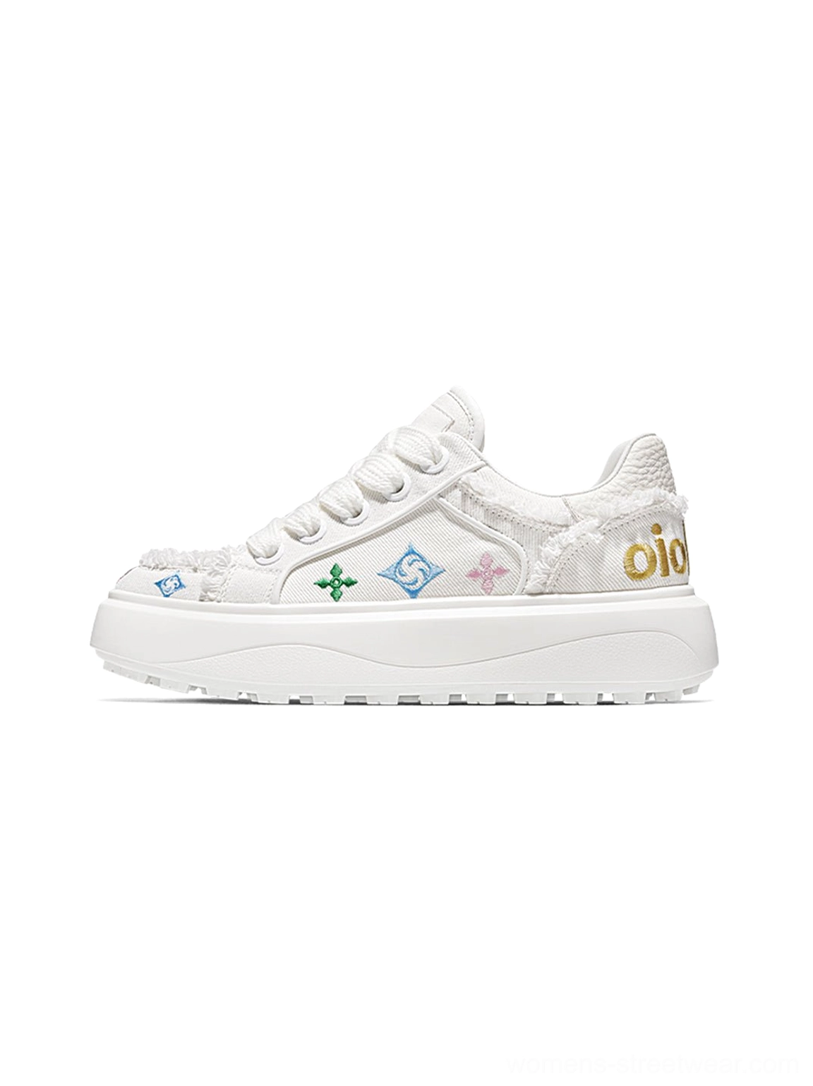 Side view of white platform skate sneakers with colorful embossed graphic motifs frayed canvas panels and thick rubber sole
