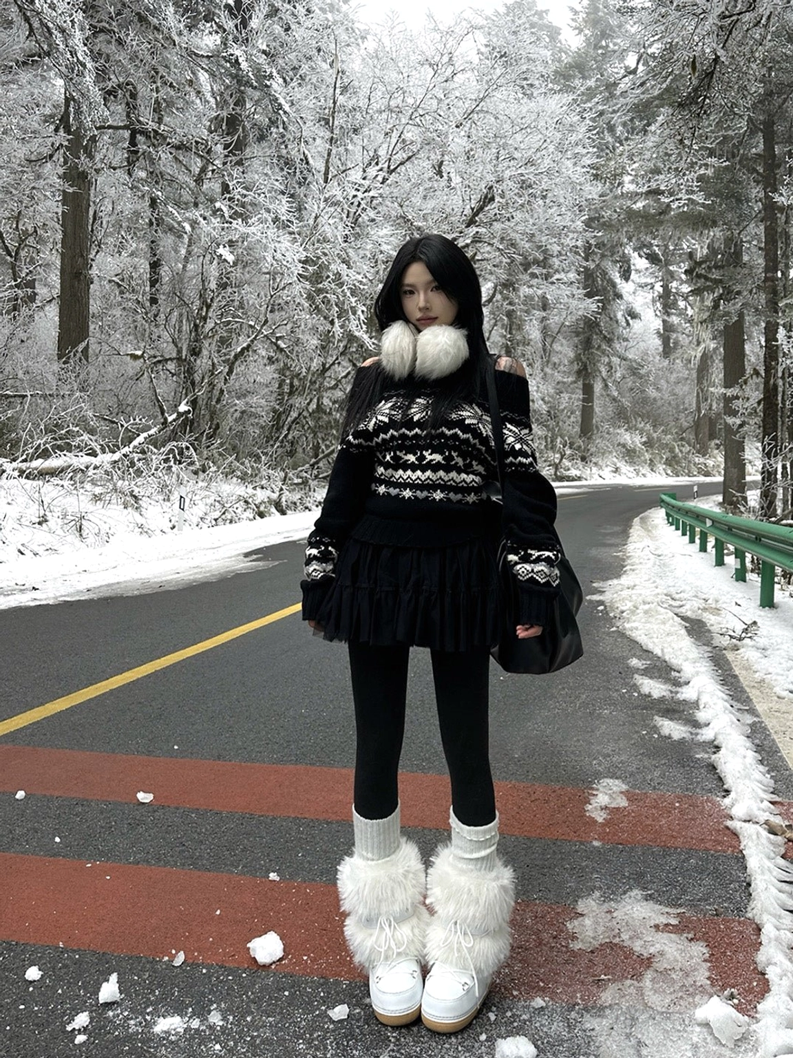 White faux fur snow boots styled with a fair isle sweater, black skirt, leggings, and winter accessories on a snowy road