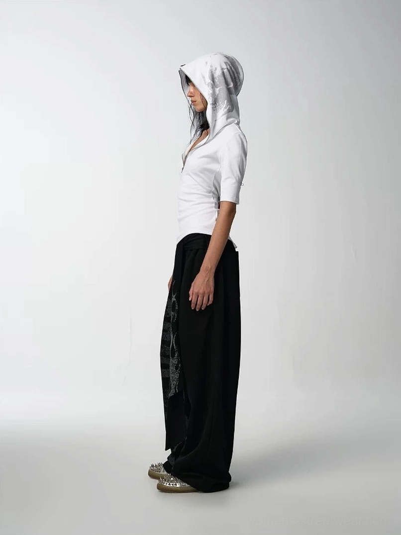 Side view of a white fitted cropped hooded half-sleeve tee paired with high-waisted black printed wide-leg pants