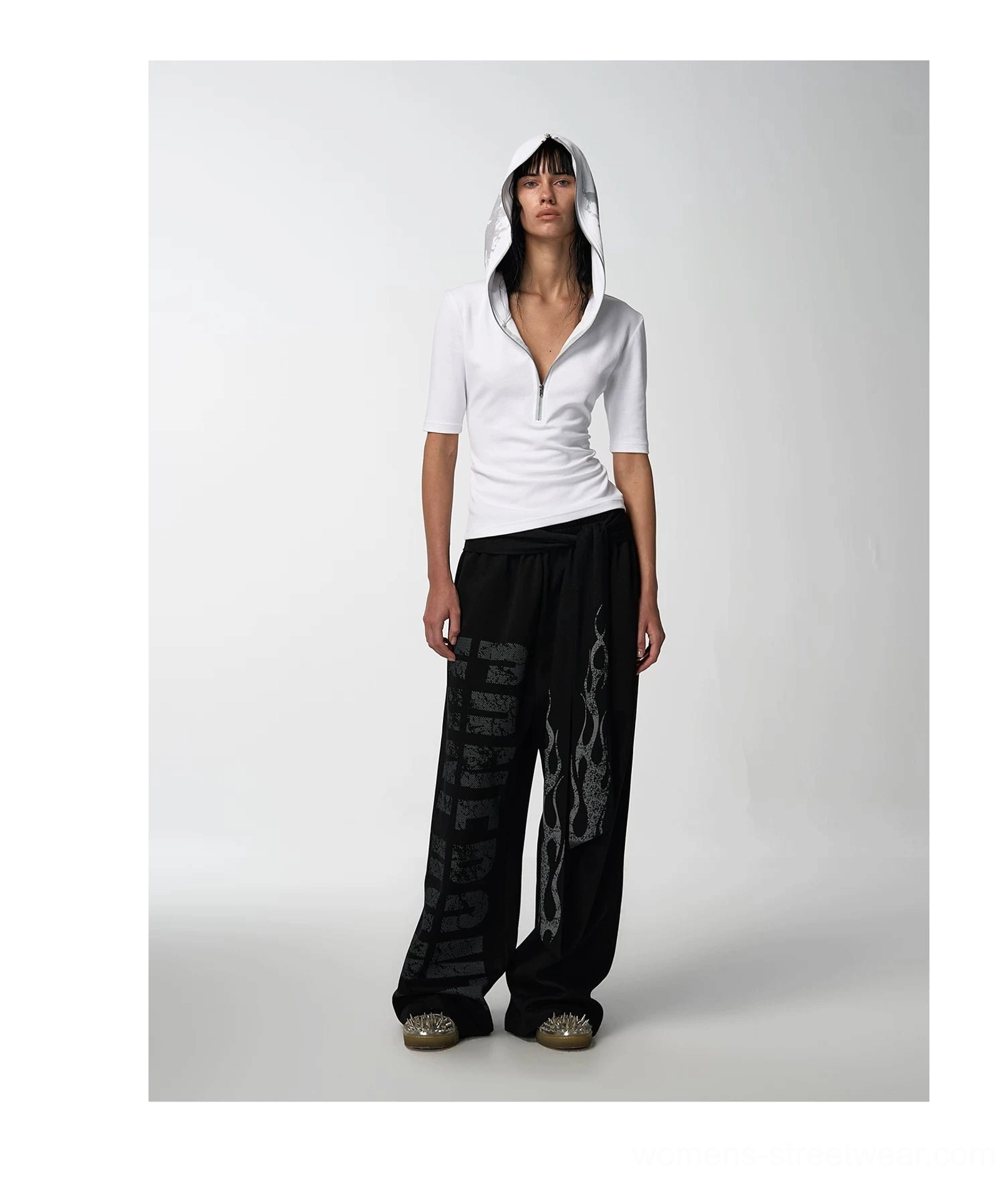 Front three-quarter view of a white fitted hooded half-sleeve streetwear tee with black printed wide-leg pants