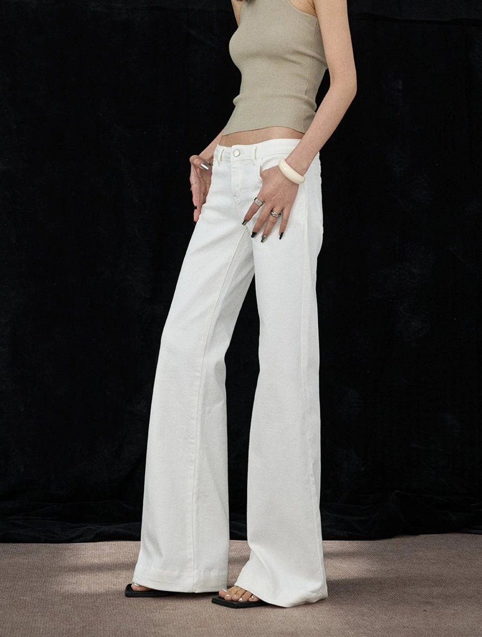 White flare denim jeans featuring button and zipper fly closure with a long full-length leg design