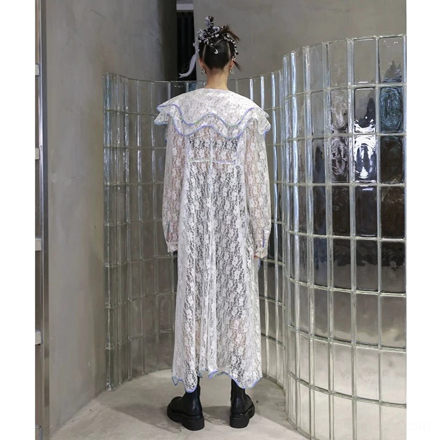 Back full body view of a white sheer floral lace duster coat featuring a matching ruffled sailor collar, flowing lace back panel, long sleeves, and avant-garde streetwear silhouette