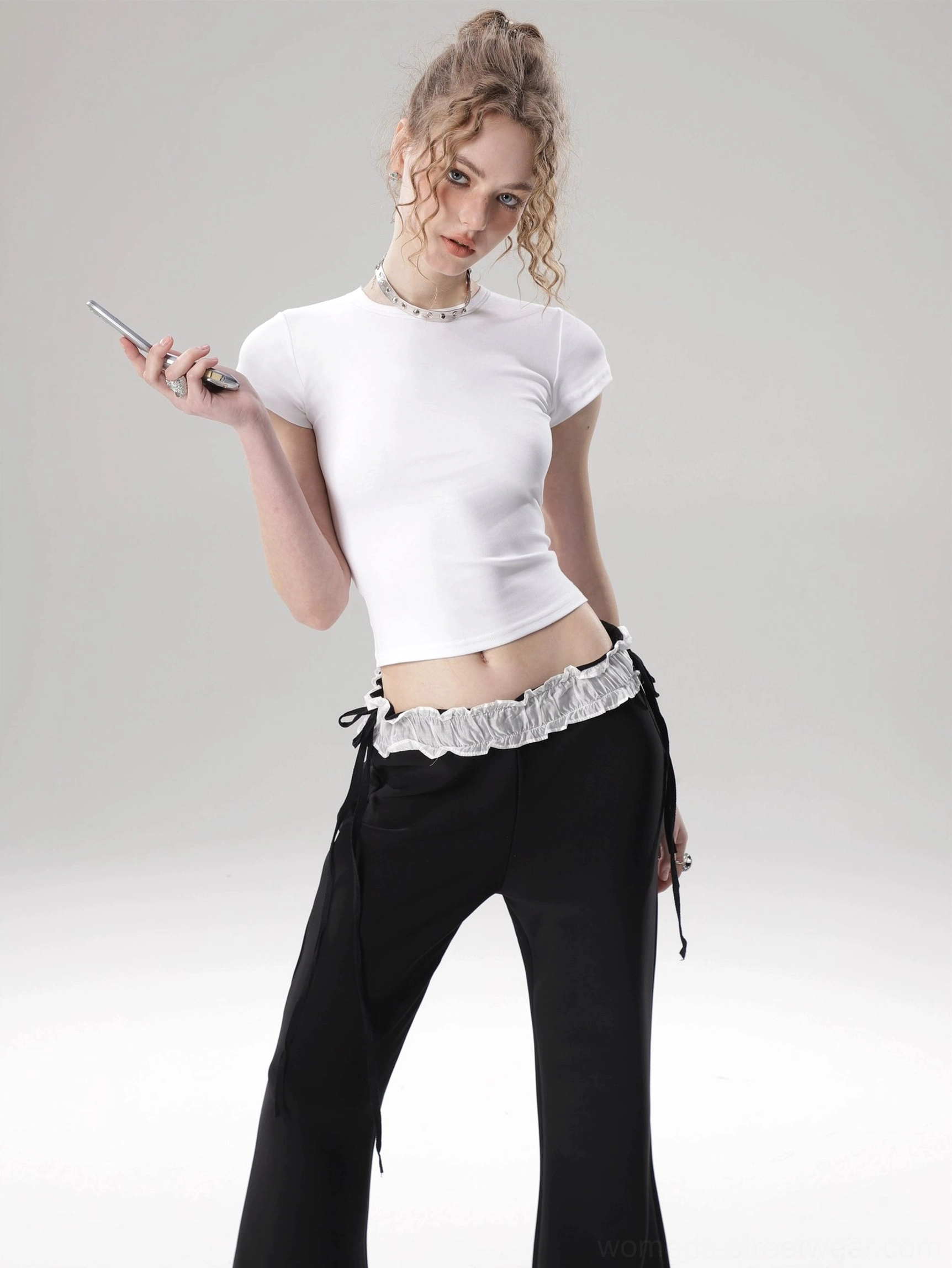 White fitted cropped top with soft flutter sleeves and crew neckline shown in a front three-quarter fashion view