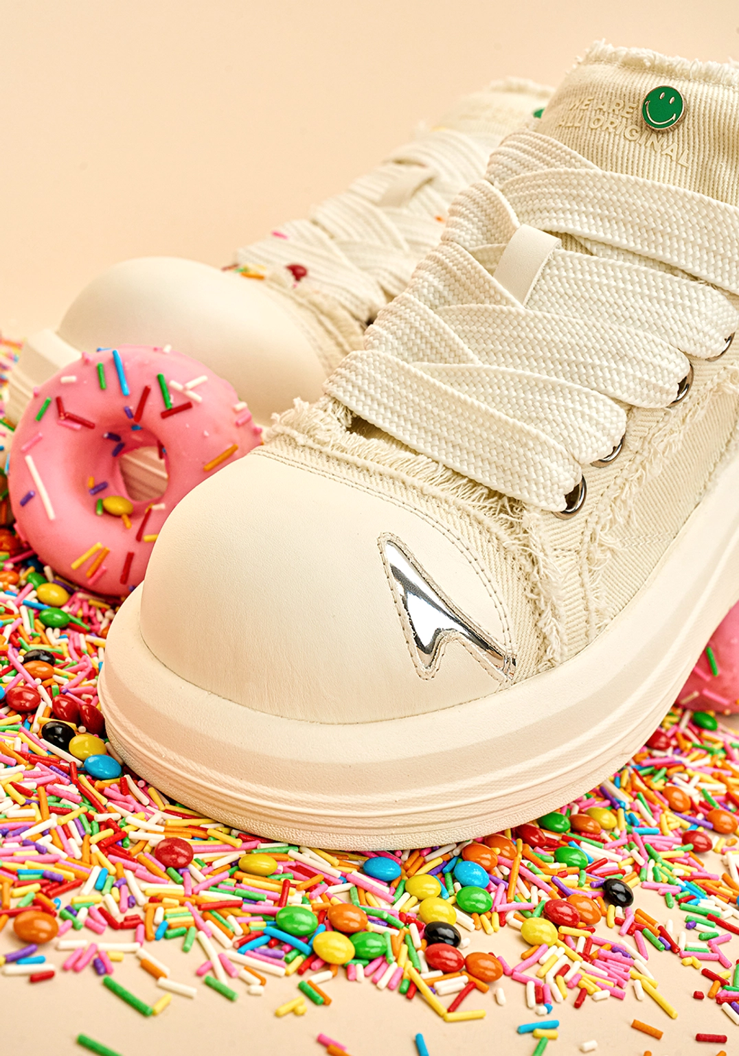 Front close-up of white frayed canvas chunky platform skate sneakers showing rounded toe and wide flat laces