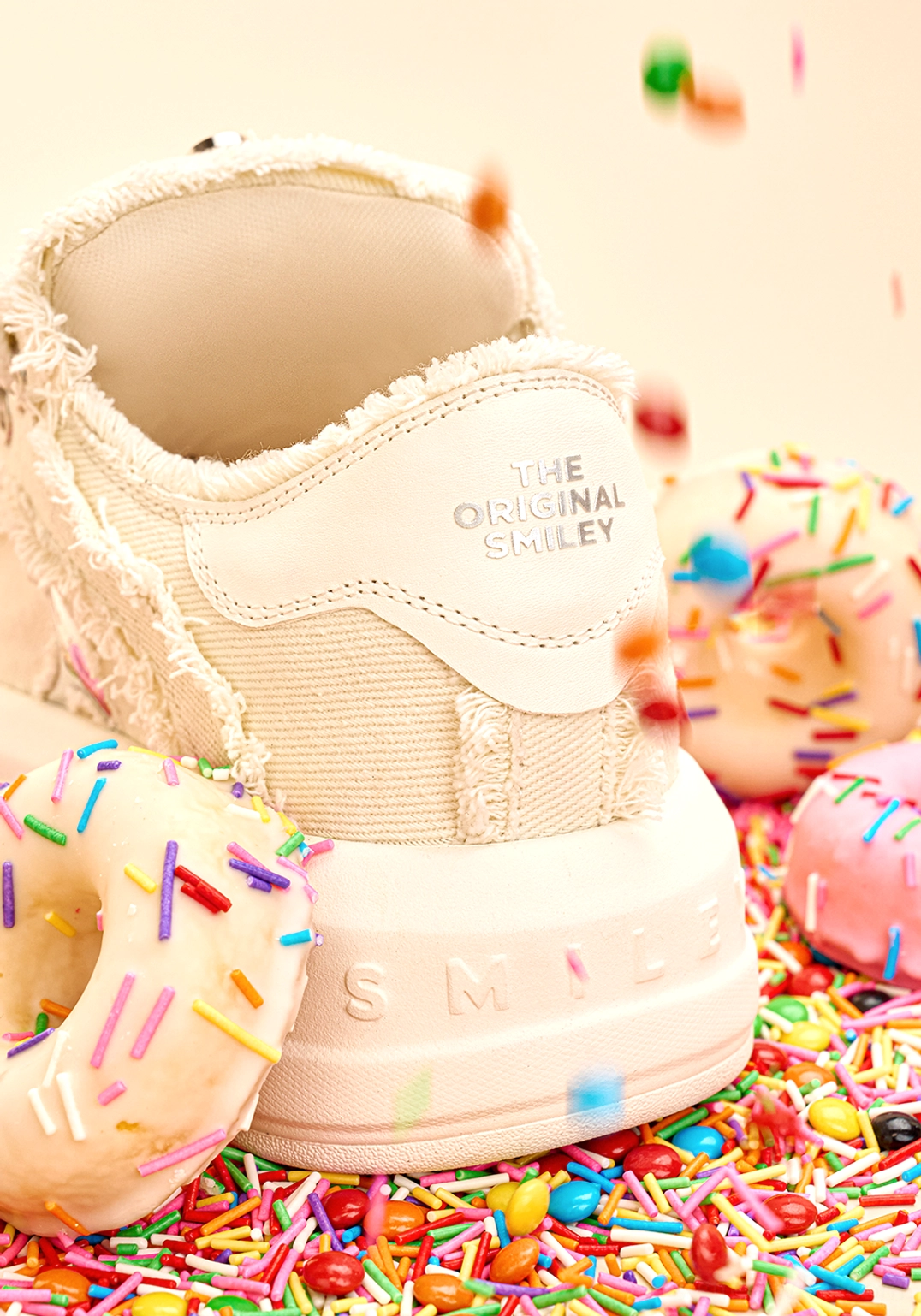 Heel close-up of white frayed canvas chunky platform skate sneakers with embossed graphic detail and green heel tab