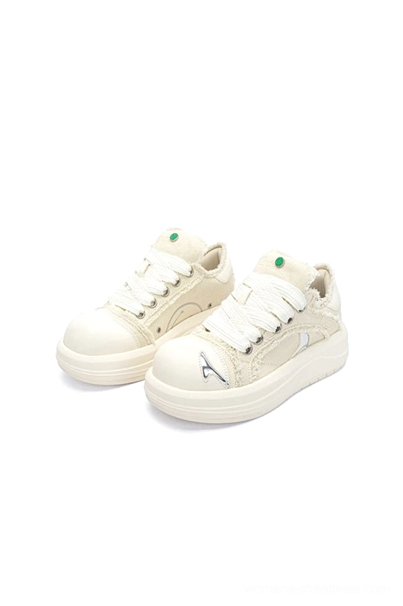 Pair of white chunky platform skate sneakers viewed from above with frayed canvas uppers and metallic decorative details