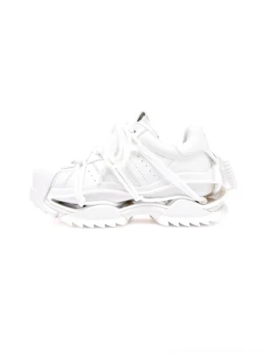 White futuristic chunky runner sneakers shown from a left side three quarter angle with layered strap details, oversized laces, smooth monochrome upper, and deeply sculpted lug platform sole