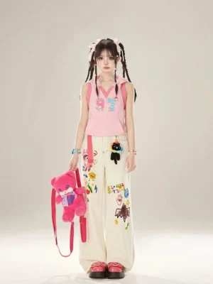 White graffiti wide-leg jeans styled with a pink cropped top, pink platform shoes, twin braids, and a colorful Y2K streetwear outfit