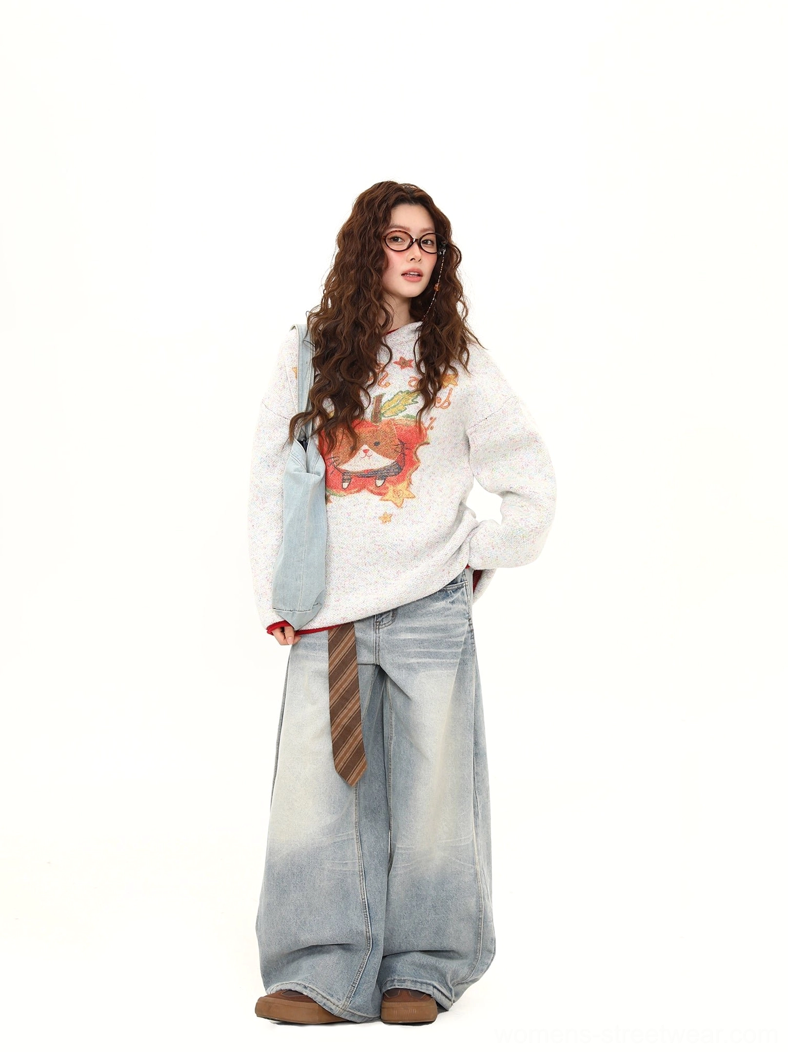 White gray oversized cat apple graphic knit sweater with red trim styled with wide-leg jeans and a blue crossbody bag