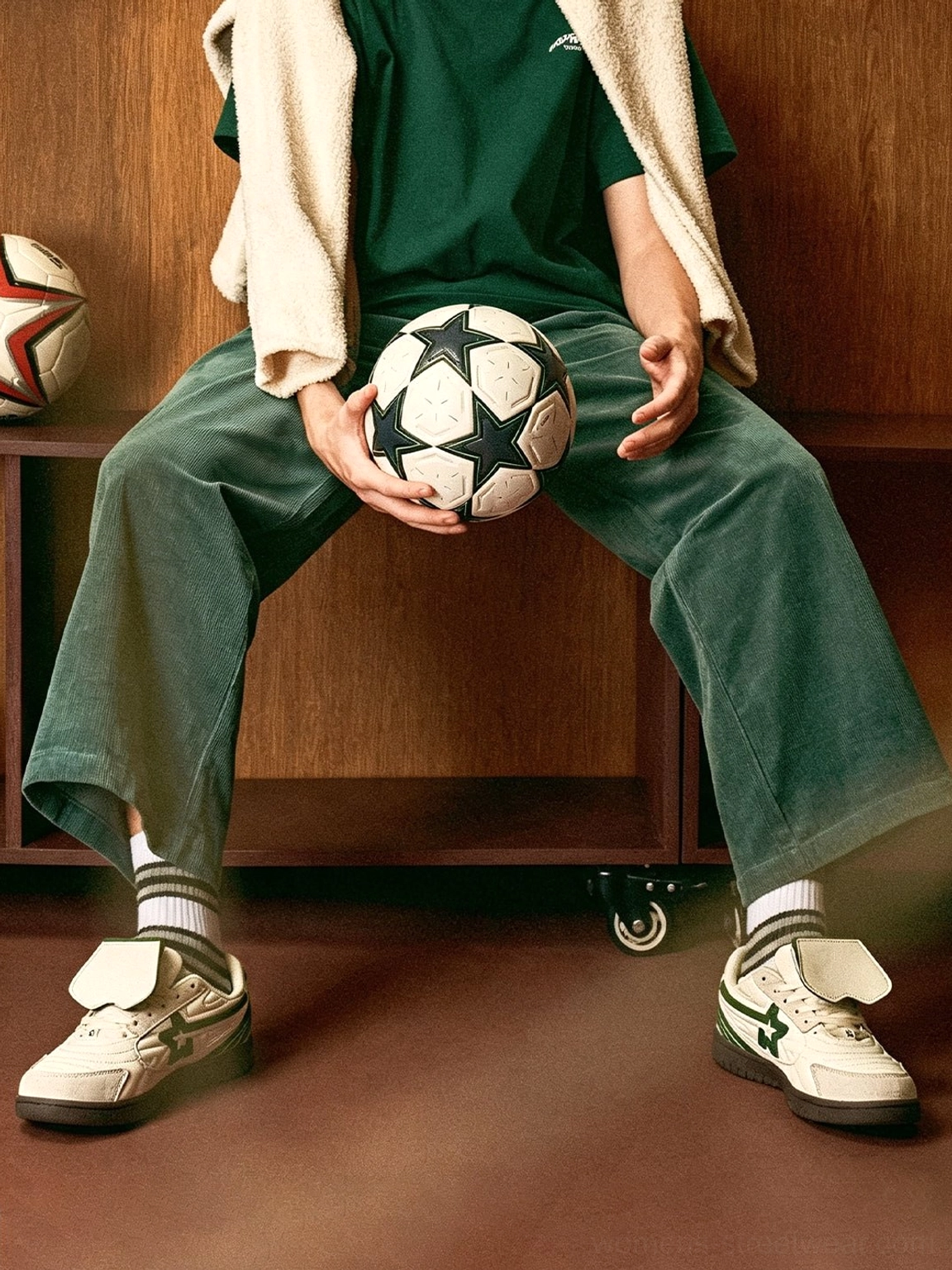 White and green detachable tongue sneakers styled with green streetwear clothing striped socks and a soccer ball