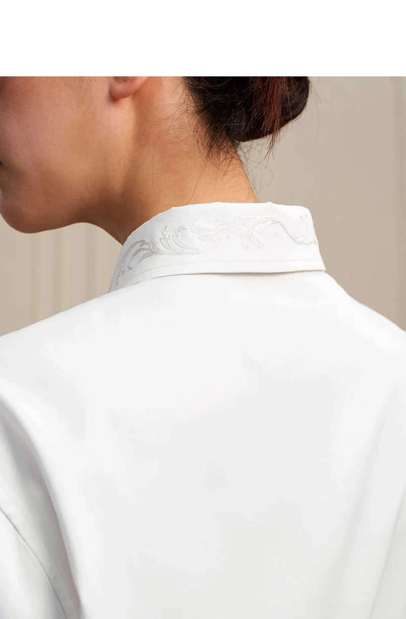 Back close-up of white high-low shirt collar showing detailed baroque embroidery on the lapel
