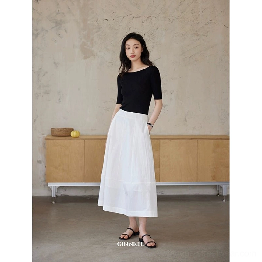 Full front view of white high waist maxi skirt with a black fitted boat neck top in minimalist Korean streetwear styling