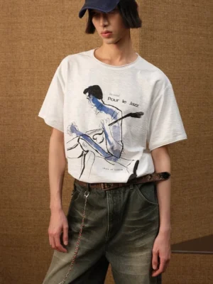 White jazz graphic T-shirt styled with wide-leg jeans showing blue watercolor musician artwork and Pour le Jazz lettering