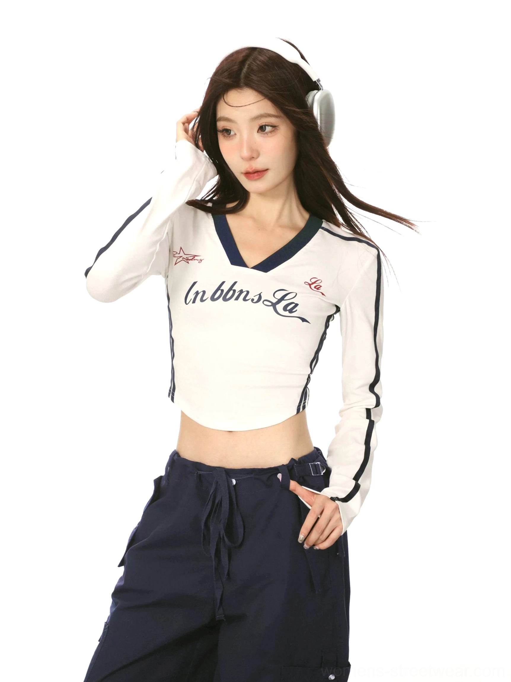 Three-quarter view of a white Korean streetwear cropped long sleeve shirt with navy V-neck trim, retro letter print, and curved hem
