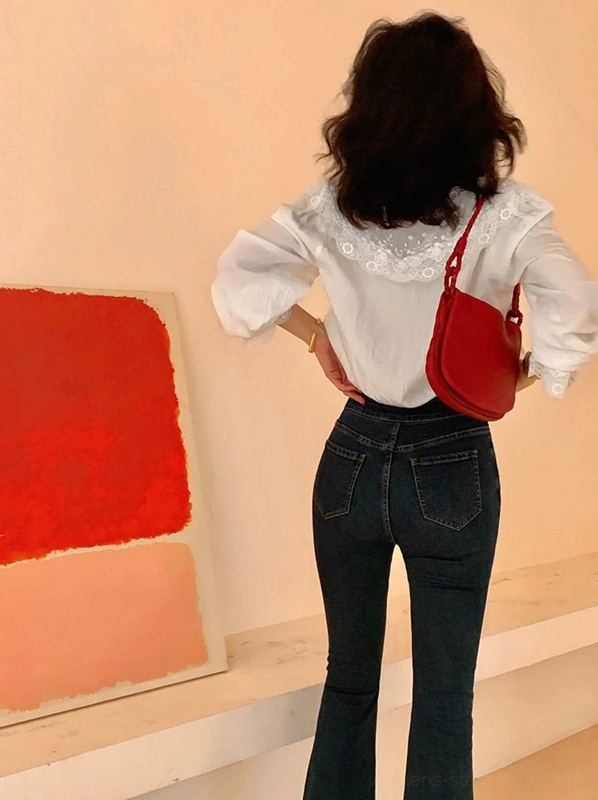 Full back view of a white lace collar blouse with ruffled details paired with high-waisted dark jeans and a maroon shoulder bag