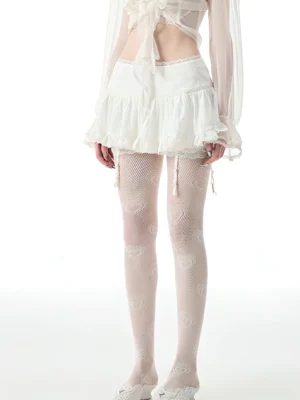 White lace ruffle mini skirt styled with heart print fishnet stockings in a romantic Y2K streetwear outfit