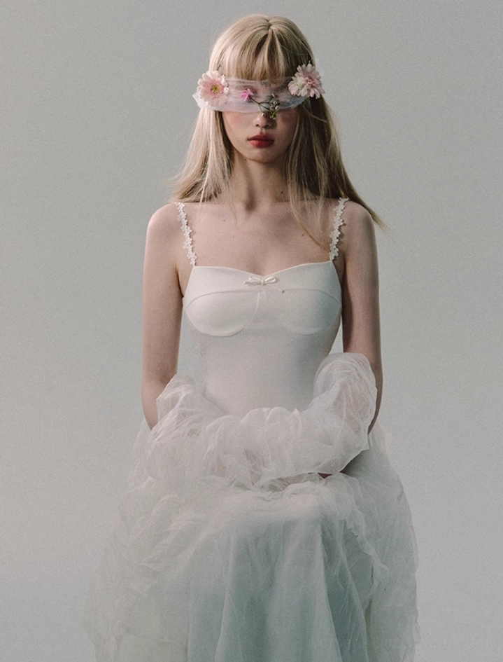 Front seated view of white lace strap tulle gown showing sweetheart neckline, mini satin bow, and softly draped tulle skirt