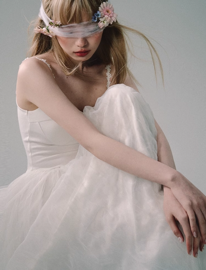 Side view of white lace strap tulle gown with streamlined fitted bodice and flowing soft floor-length skirt